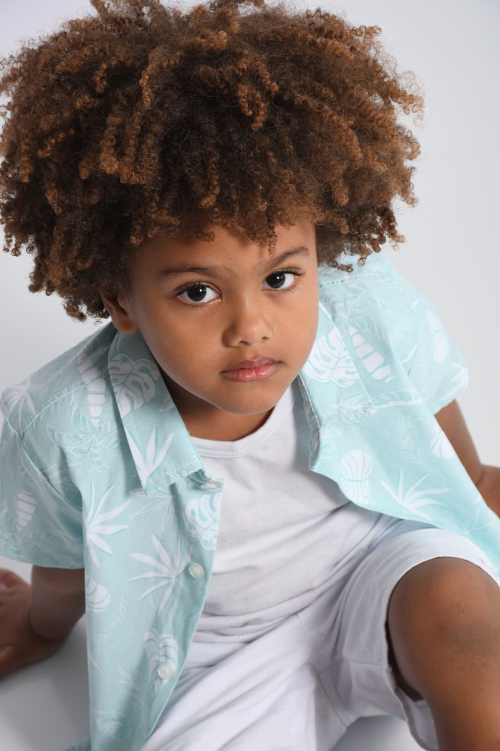 Isaac Roberto de camisa floral verde-água, olhando para a câmera